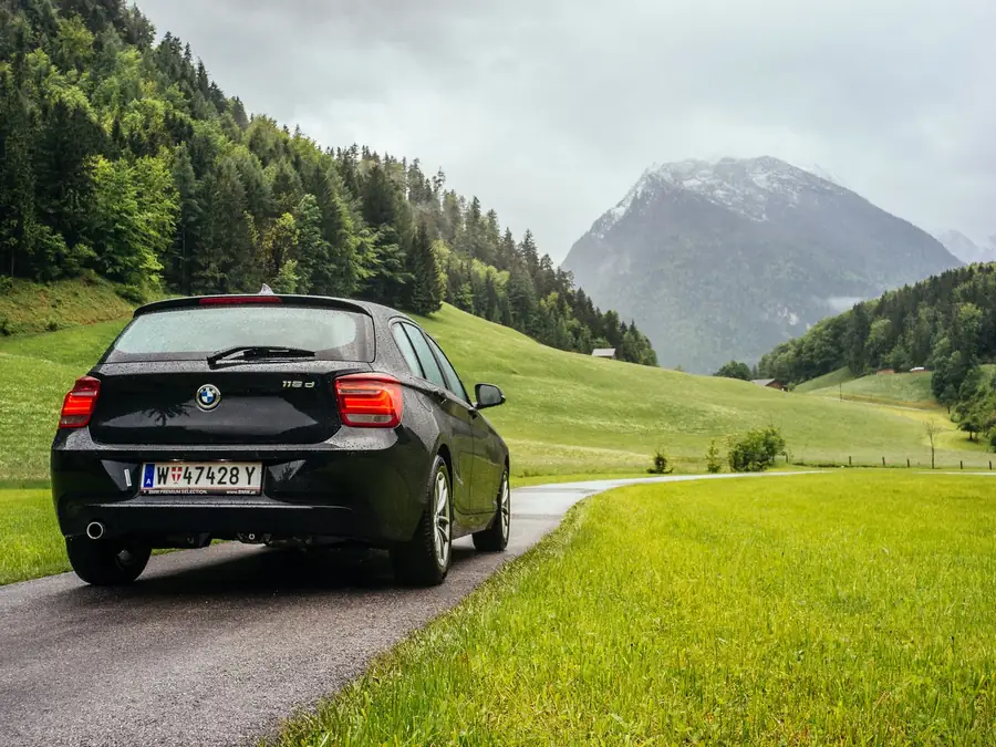 Black BMW 118i M Sport hatchback on a mountain road