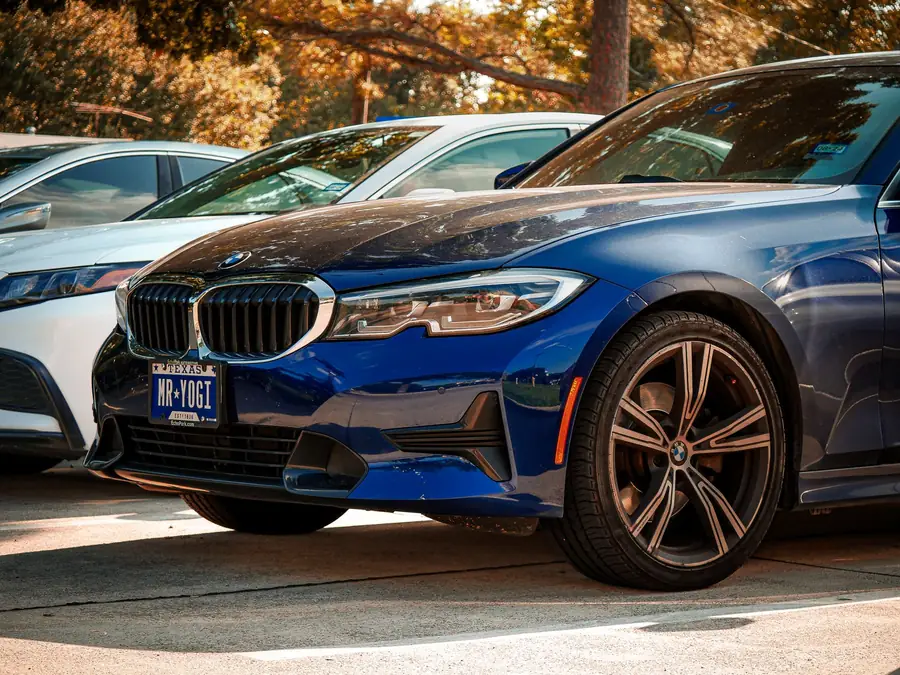 Blue BMW 330i M Sport parked in a line of cars on the JE Auto forecourt
