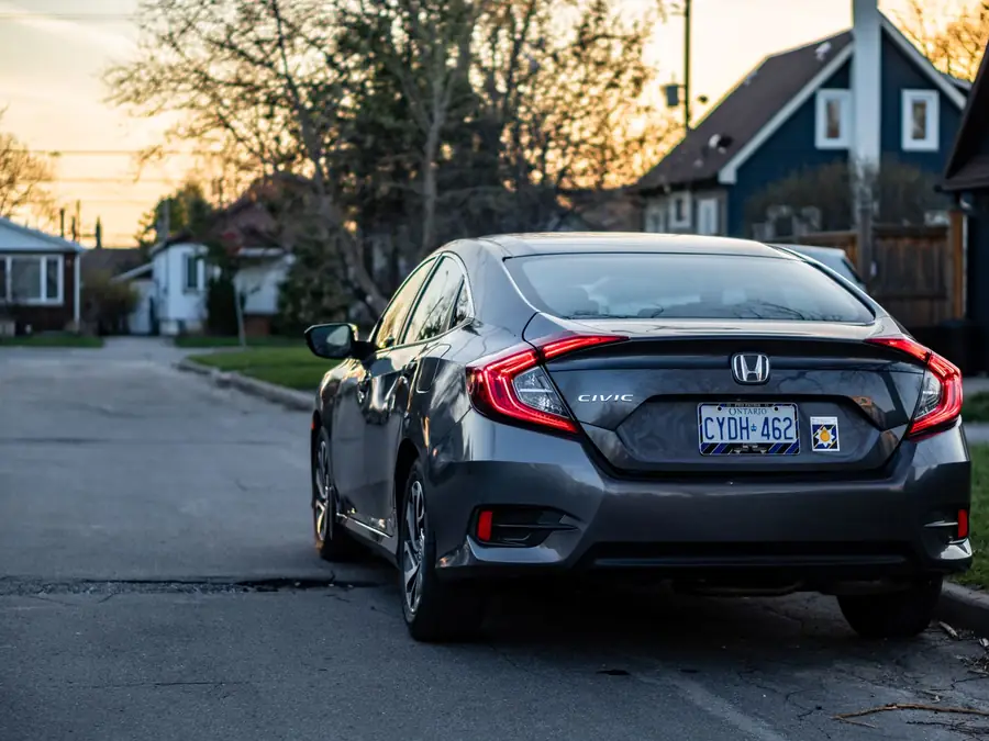 Grey Honda Civic 1.8 S seen from behind on a quiet residential street at sunset